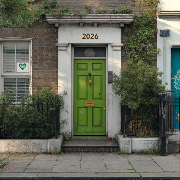 A green door with the number "2026" above and a BLCS Heart leaflet in the window.